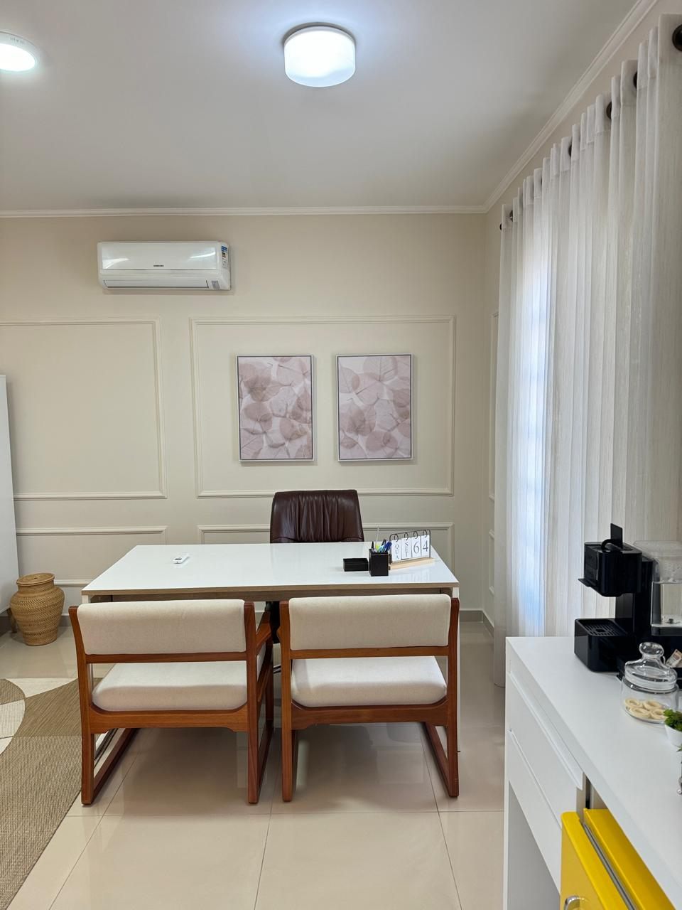 Sala de atendimento do consultório, mesa de trabalho e poltronas para pacientes